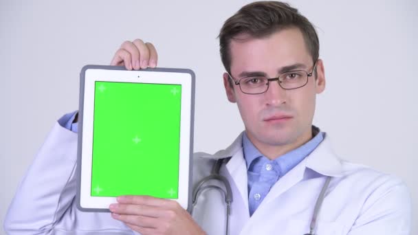 Junger glücklicher schöner Mann Arzt zeigt digitales Tablet — Stockvideo