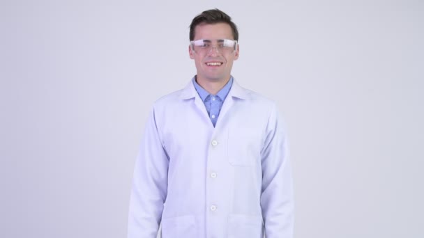 Gelukkig knappe jongeman arts een beschermende bril met armen gekruist — Stockvideo