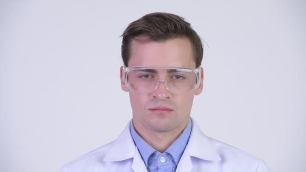 Young happy handsome man doctor wearing protective glasses — Stock Video