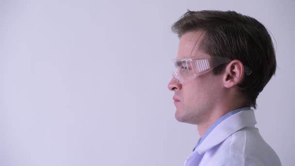 Vue du profil de jeune homme heureux et beau médecin portant des lunettes de protection — Video