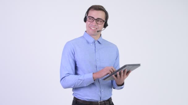 若いハンサムな実業家の身に着けているヘッドセットと白の背景にクロマキーに対してメガネのスタジオ撮影 — ストック動画