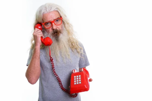 Studio shot van senior bebaarde man praten op oude telefoon — Stockfoto