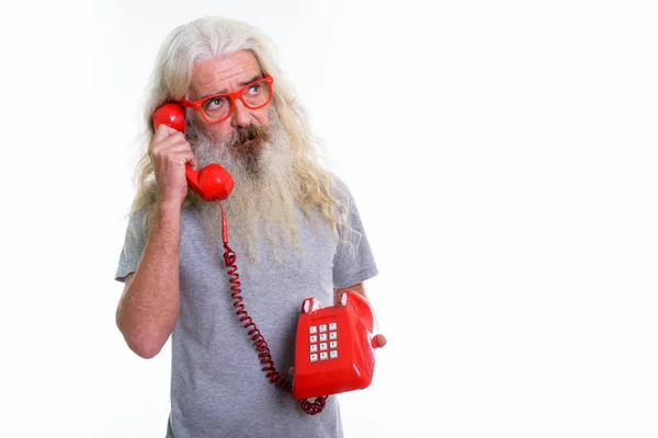 Studio shot van senior bebaarde man denken tijdens het gesprek op oude — Stockfoto