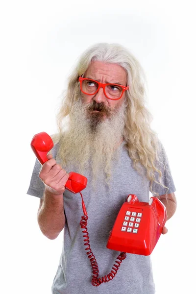 Studio shot van senior bebaarde man houdt van oude telefoon terwijl th — Stockfoto