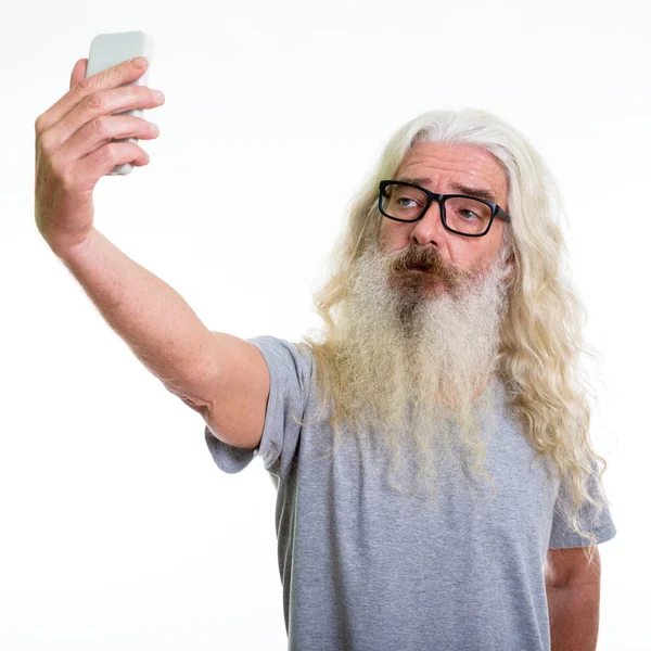 Studio shot van senior bebaarde man nemen selfie foto met mob — Stockfoto