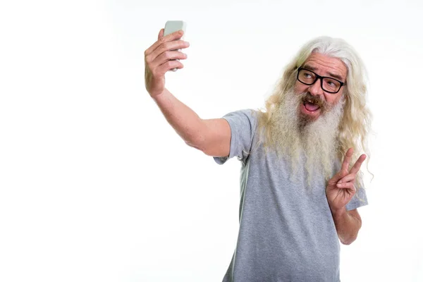 Studio shot van gelukkig senior bebaarde man glimlachend en vrede geven — Stockfoto