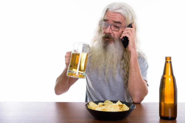 Prise de vue en studio d'un homme barbu âgé parlant sur son téléphone portable — Photo