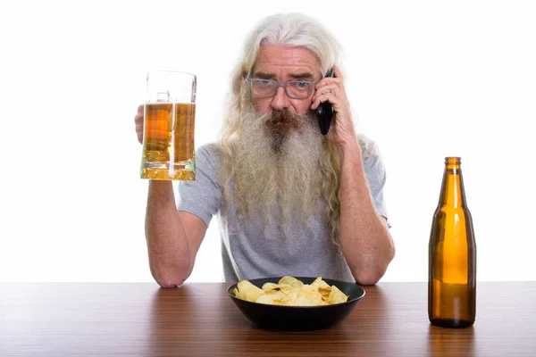 Studioaufnahme eines älteren bärtigen Mannes, der mit dem Handy telefoniert, während — Stockfoto