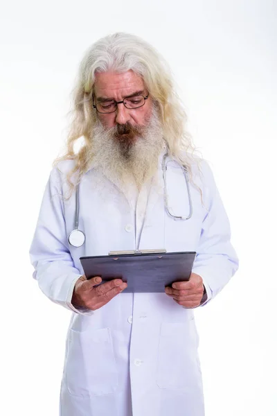Студійний знімок старшого бородатого лікаря, який читає в буфері — стокове фото