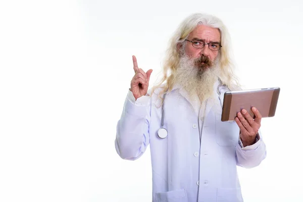 Студійний знімок старшого бородатого лікаря, який думає, вказуючи — стокове фото
