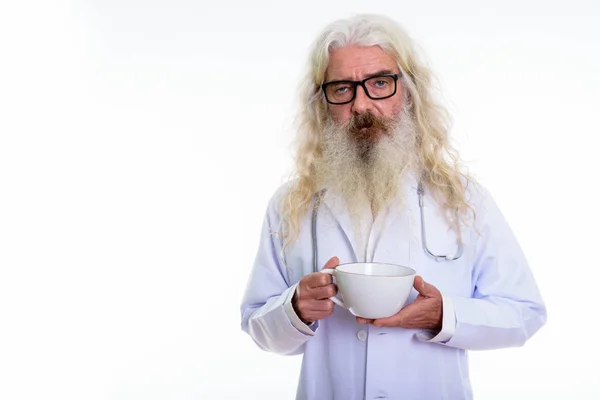 Estudio de hombre barbudo mayor médico sosteniendo taza de café — Foto de Stock