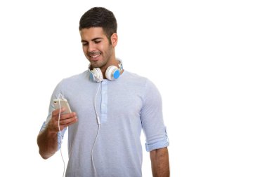 Gülümseyen ve wea iken cep telefonunuzu kullanarak mutlu Farsça delikanlı