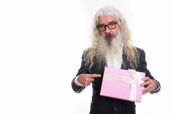 Studio shot of senior bearded businessman holding and pointing a — Stock Photo, Image