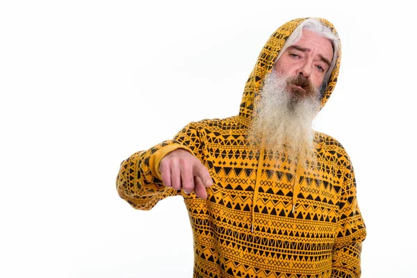 Studio skott av äldre skäggig man bär hoodie samtidigt pekar — Stockfoto