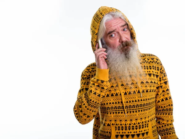 Studio shot of senior bearded man wearing hoodie while talking o — Stock Photo, Image