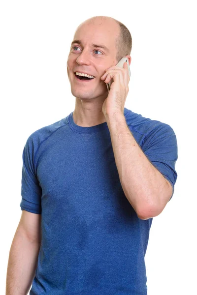 Przemyślane szczęśliwy łysy kaukaski mężczyzna uśmiecha się i mówi na mobil — Zdjęcie stockowe