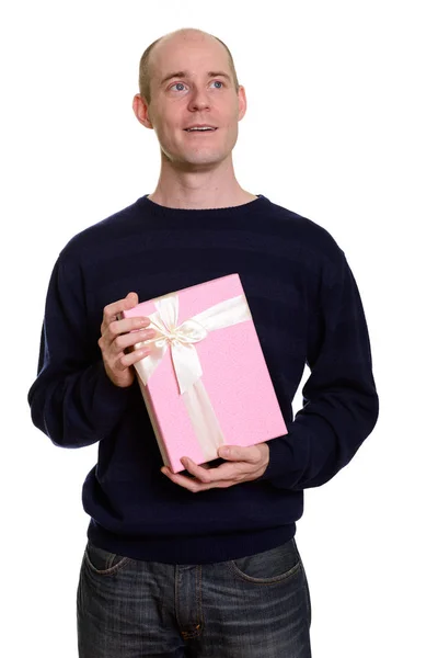 Στοχαστική ευτυχισμένη φαλακρός Καυκάσιος άνδρας χαμογελά και κρατώντας κουτί δώρου — Φωτογραφία Αρχείου