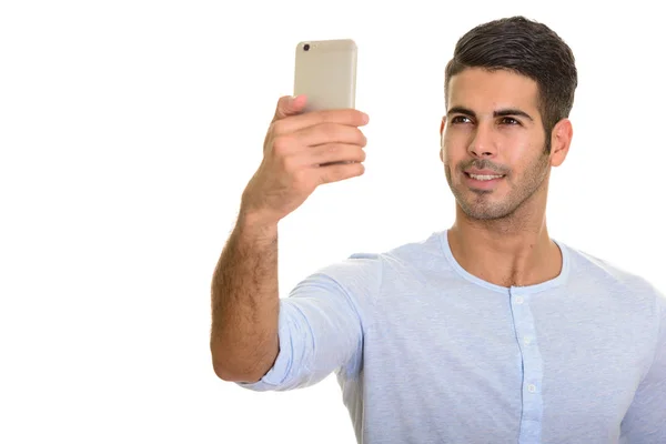 Boldog perzsa fiatalember mosolyogva, és figyelembe véve a ph mobil selfie — Stock Fotó