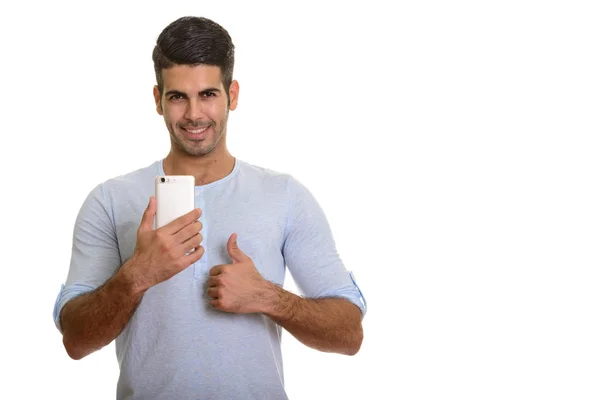 Boldog perzsa fiatalember mosolyogva, miközben mozgatható telefon és g — Stock Fotó