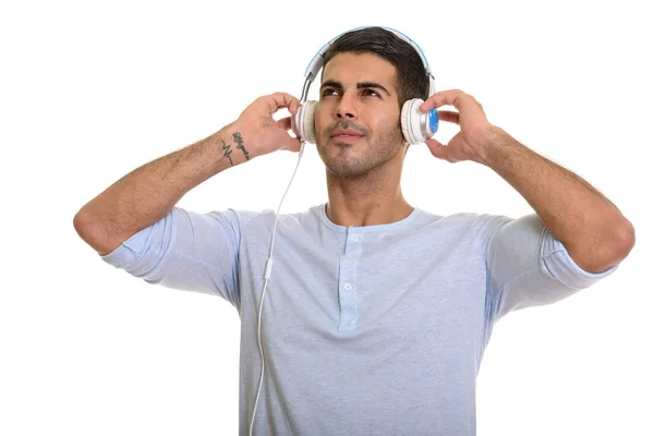 Jovem homem persa feliz sorrindo enquanto ouve música — Fotografia de Stock