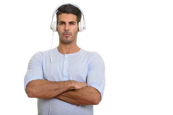 Młody przystojny pasuje Perski człowiek słuchanie muzyki z broni cros — Zdjęcie stockowe