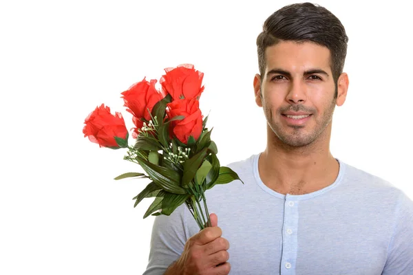 Jovem feliz persa homem sorrindo enquanto segurando rosas vermelhas pronto fo — Fotografia de Stock