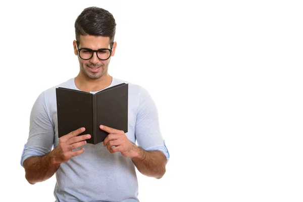 Молодой счастливый перс улыбается во время чтения книги — стоковое фото