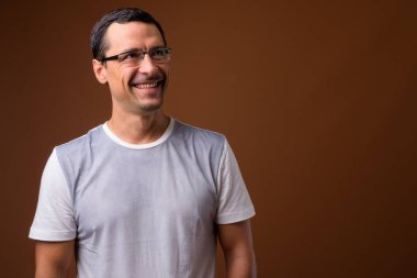Kahverengi arka planı düşünerek mutlu bir adam portresi
