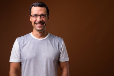 Kahverengi arka planı gülümseyerek mutlu bir adam portresi