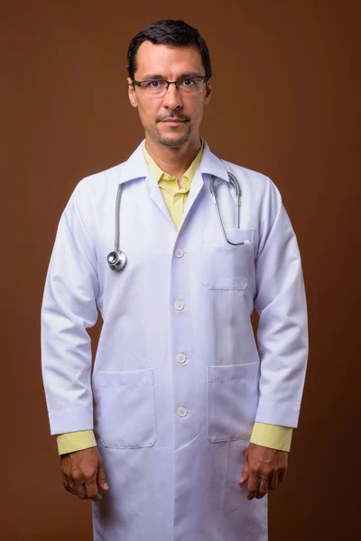 Jóképű férfi orvos barna háttér portréja — Stock Fotó