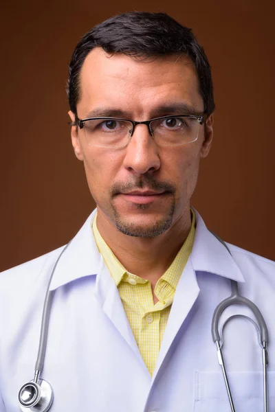 Retrato de hombre guapo médico cara contra fondo marrón —  Fotos de Stock