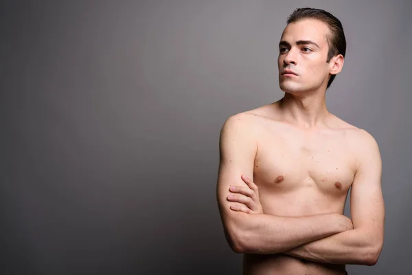 Joven hombre guapo sin camisa con los brazos cruzados pensando —  Fotos de Stock