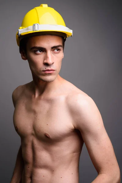 Guapo sexy hombre de construcción trabajador sin camisa contra gris ba —  Fotos de Stock