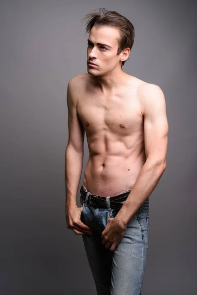 Joven hombre guapo sin camisa sobre fondo gris — Foto de Stock