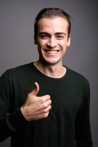 Jonge knappe man glimlachend en duim opgevend — Stockfoto