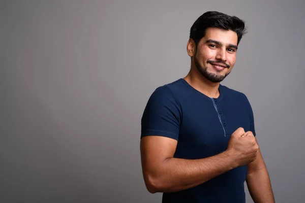 Joven guapo barbudo persa hombre sobre fondo gris — Foto de Stock