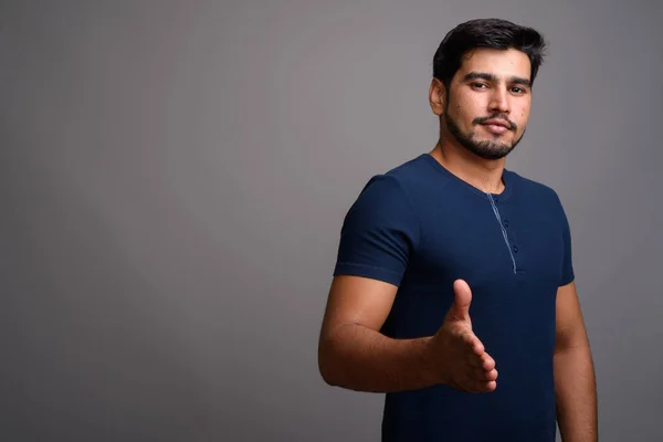 Joven guapo barbudo persa hombre sobre fondo gris — Foto de Stock