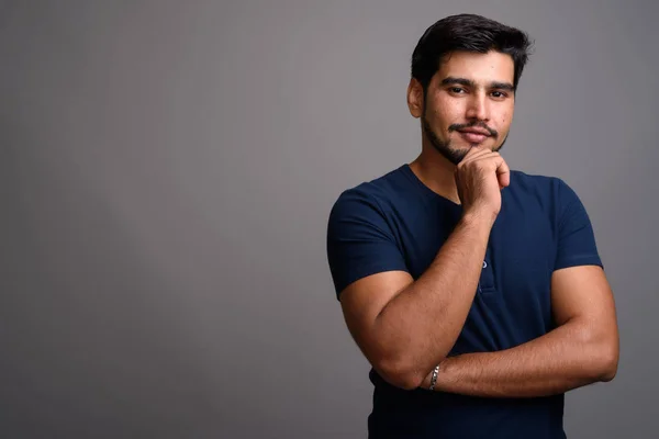 Joven guapo barbudo persa hombre sobre fondo gris — Foto de Stock