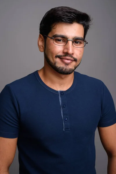 Joven guapo barbudo persa hombre sobre fondo gris — Foto de Stock