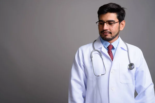Ung snygg skäggiga Persiska man läkare mot grå bak — Stockfoto