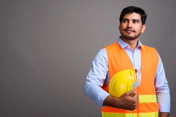 Genç yakışıklı sakallı Farsça adam inşaat işçisi g karşı — Stok fotoğraf
