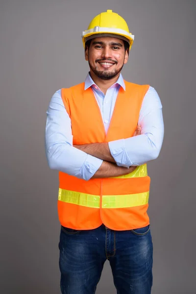 Joven guapo barbudo persa trabajador de la construcción contra g — Foto de Stock