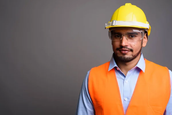 Joven guapo barbudo persa trabajador de la construcción contra g —  Fotos de Stock