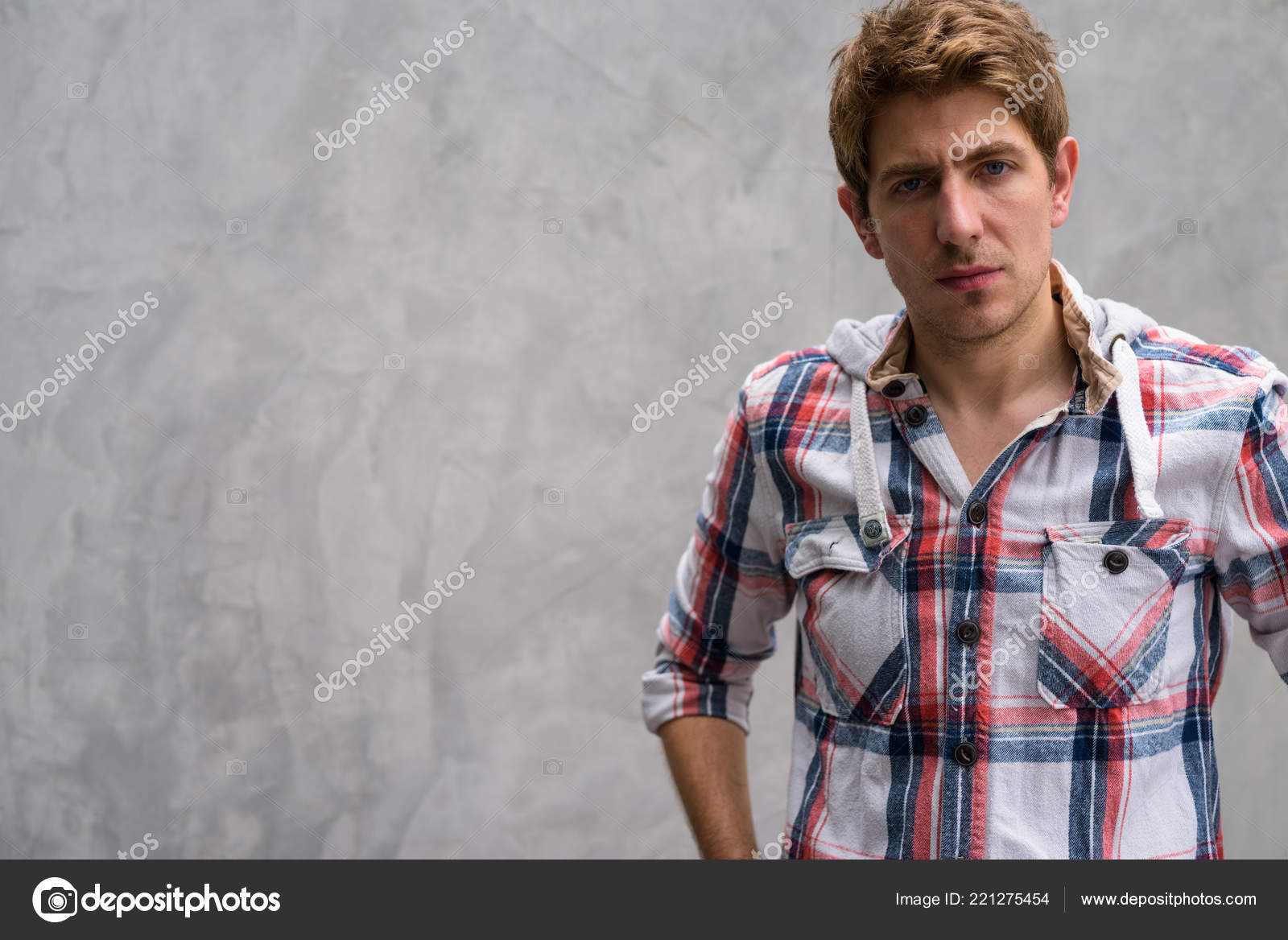 Portrait Of Handsome Man With Blond Hair Against Concrete Wall