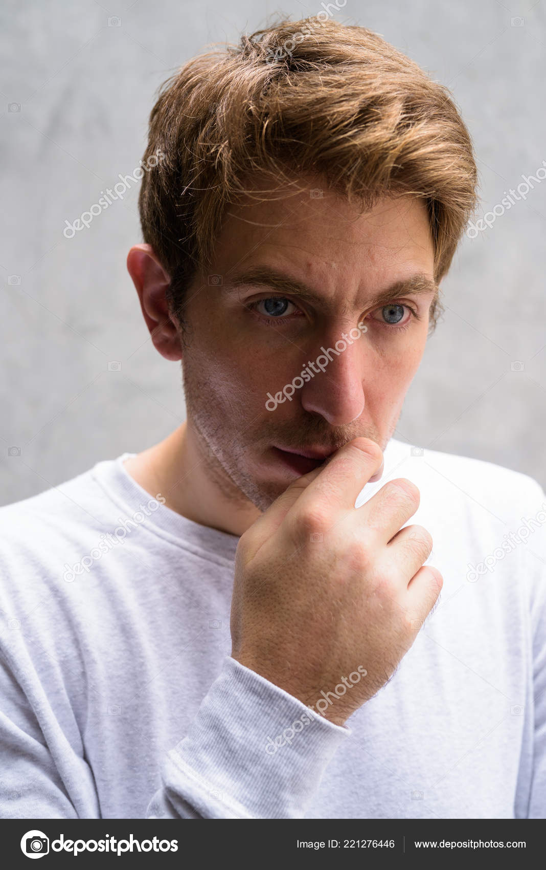 Portrait Of Handsome Man With Blond Hair Against Concrete Wall