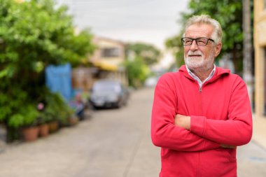 Mutlu yakışıklı kıdemli gülümseyen ve wea düşünme adam sakallı