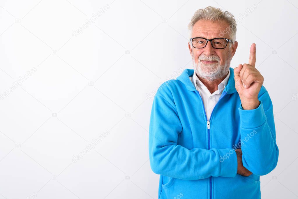 Studio shot of handsome senior bearded man pointing finger up re