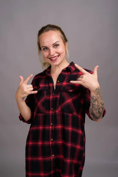 Jovem mulher bonita com cabelo loiro contra fundo cinza — Fotografia de Stock