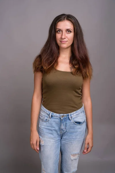 Retrato de jovem bela mulher contra fundo cinza — Fotografia de Stock