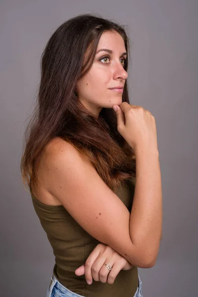 Porträt einer jungen schönen Frau vor grauem Hintergrund — Stockfoto